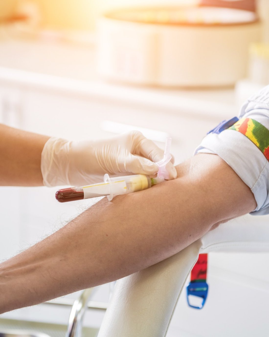 A nurse taking a blood sample from a patient's arm