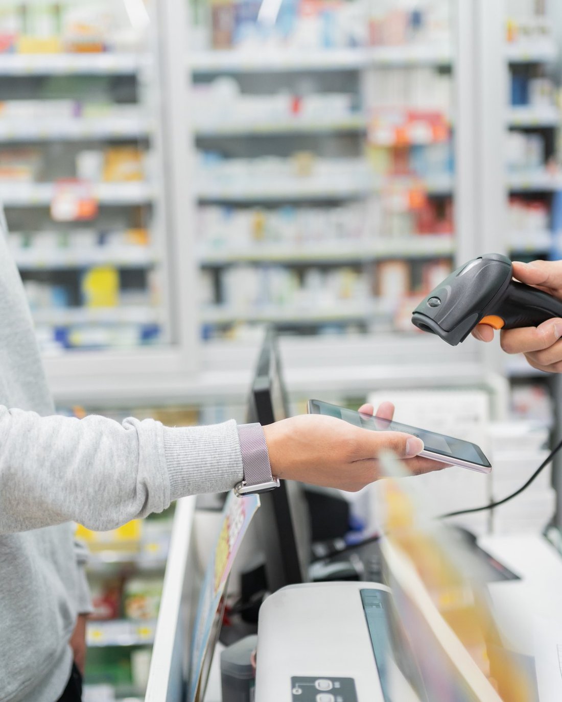A man showing his eScript on his phone at a pharmacy counter