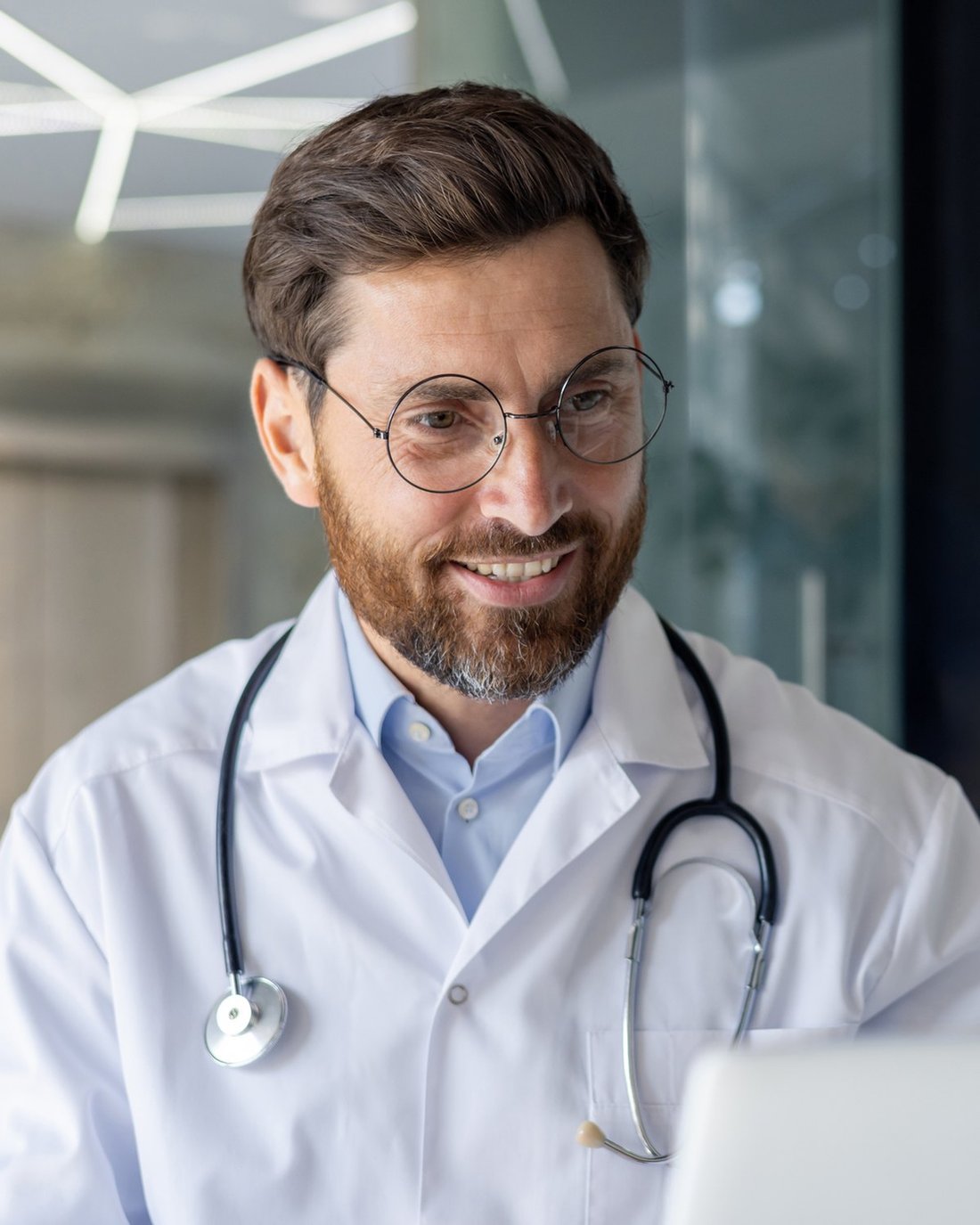 A smiling male doctor at his desk