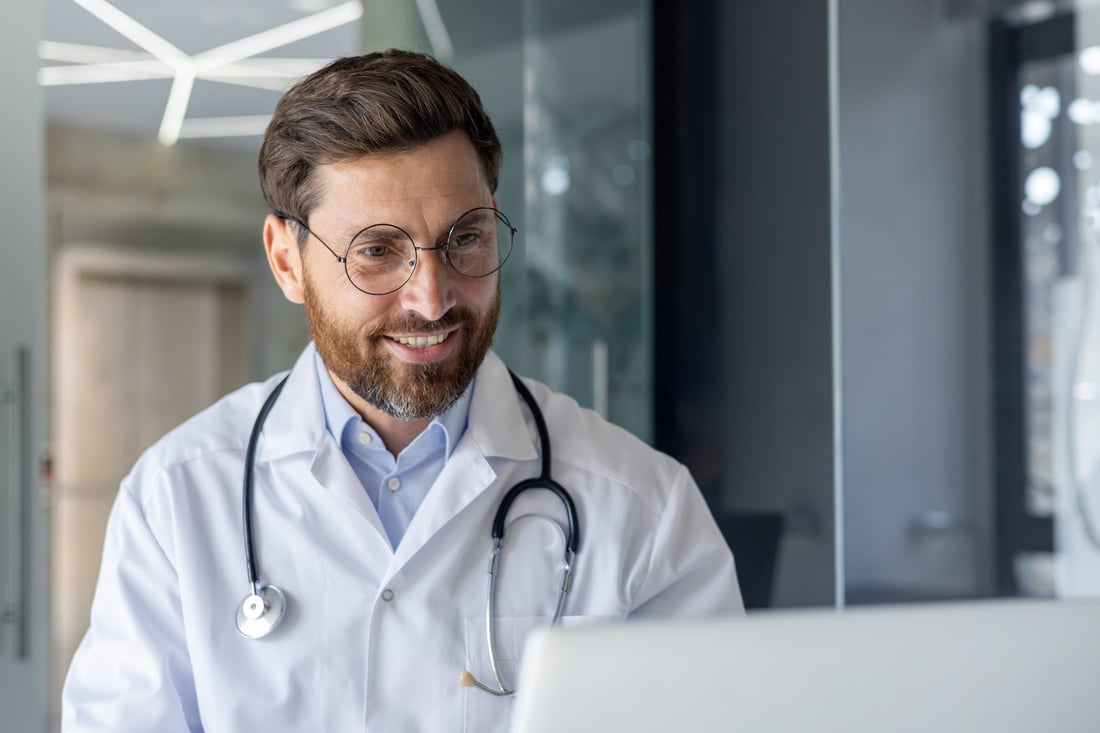 A smiling doctor at his desk